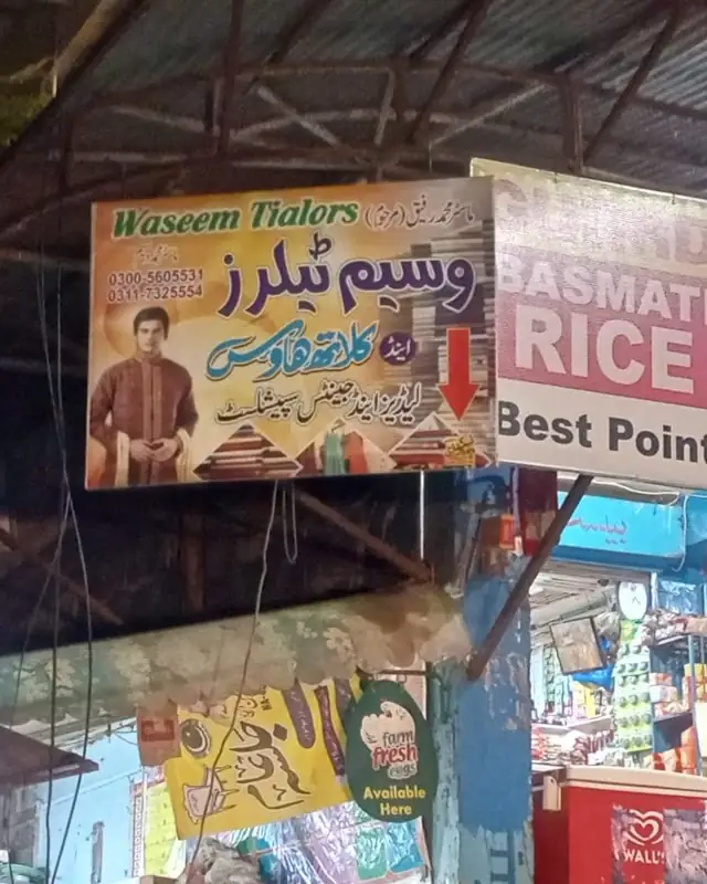 Waseem Tailors signboard at night